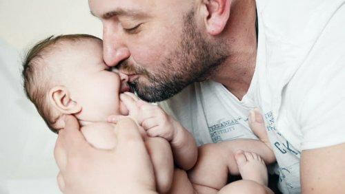 Un père fait un bisou à son bébé