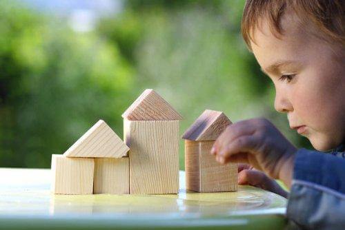 Un enfant construit une maison en bois