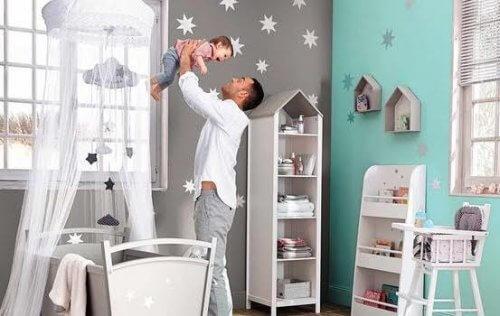 Un père avec son bébé dans sa chambre