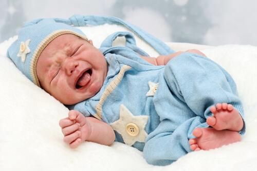 Un bébé en pyjama pleure