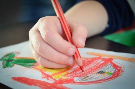 Un enfant dessine au crayon