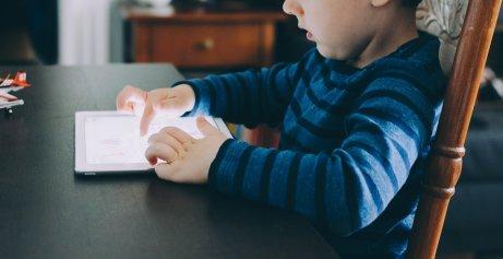 Un enfant joue sur sa tablette