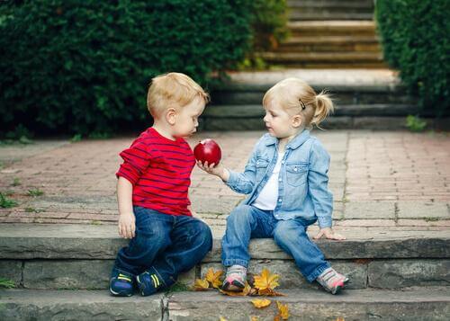 Deux enfants partagent une pomme