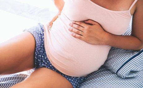 Une femme enceinte sur son lit