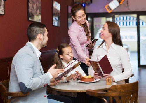 Des parents et leur fille sont au restaurant