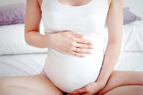 Une femme enceinte se tient le ventre