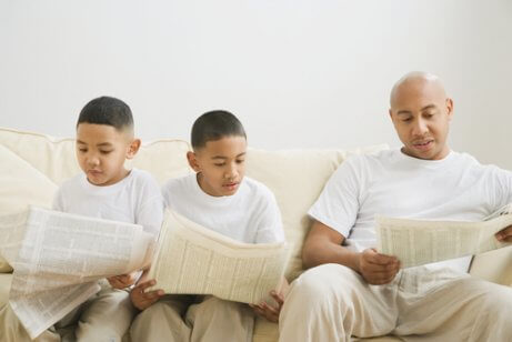 Un père lisant le journal avec ses enfants