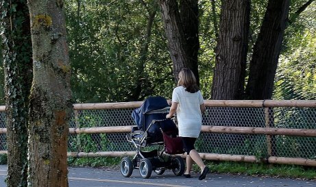 Une mère promène son enfant dans le parc