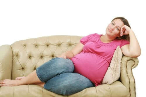 Une femme enceinte sur un sofa.