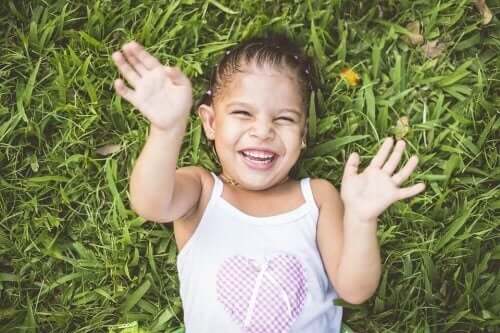 Petite fille dans l'herbe qui développe sa latéralité.