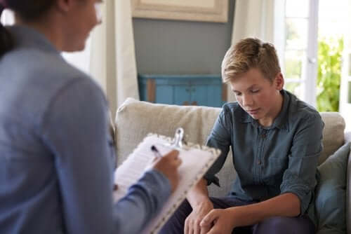 Adolescent qui parle avec un adulte qui prend des notes