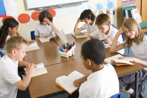 Des enfants qui lisent un livre dans une salle de classe.