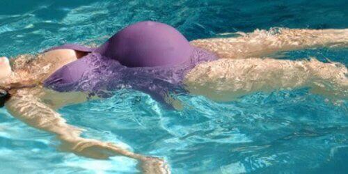 Femme enceinte dans une piscine en maillot de bain