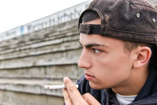 jeune homme fumant une cigarette