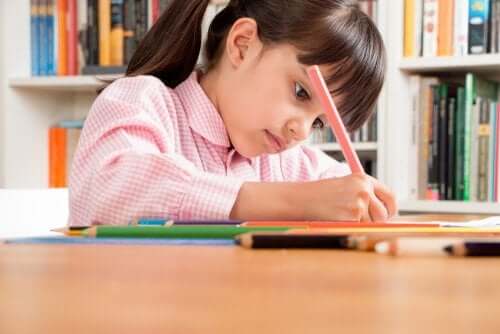 Une petite fille qui écrit dans un cahier.