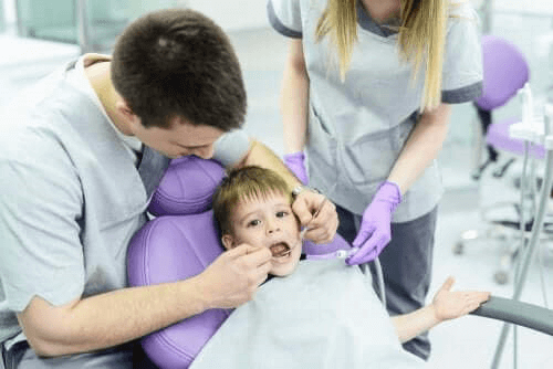 enfant chez le dentiste avec des caries dentaires