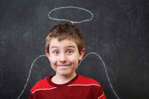 enfant devant un tableau noir avec un dessin d'ange