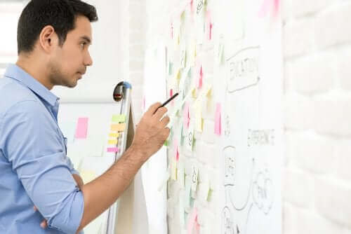 homme écrivant sur un tableau