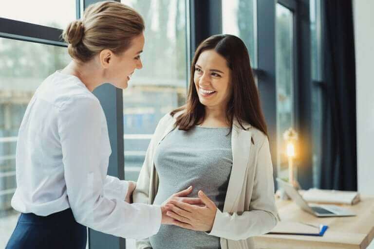 patronne touchant le ventre de son employée enceinte