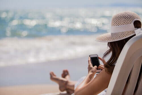 femme à la plage avec son téléphone
