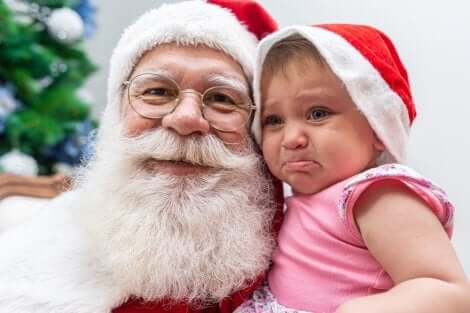 Un bébé qui pleure dans les bras du Père Noël.