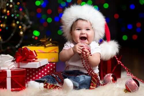 Un bébé au milieu de ses cadeaux de Noël.