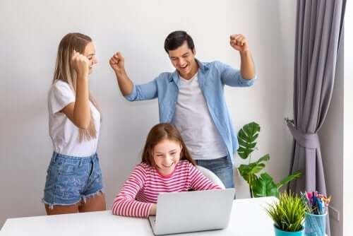 fille et ses parents devant un ordinateur