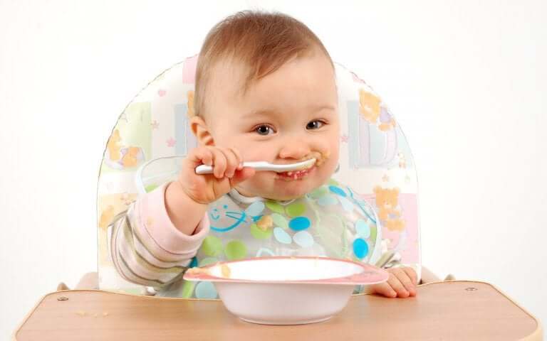 Un bébé en train de manger à la cuillère