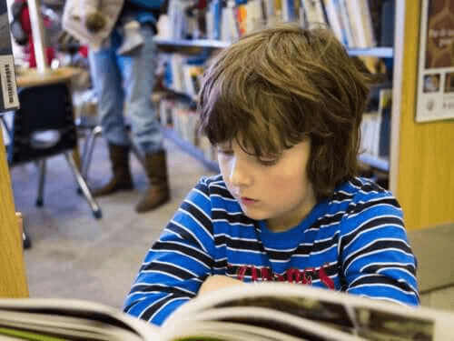 enfant lisant une bande dessinée