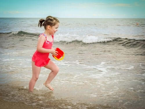 enfant à la plage avec un seau de sable