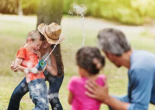 famille jouant avec un pistolet à eau à l'extérieur