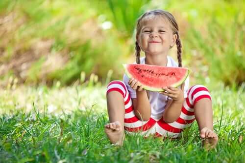 Une petite fille mange une pastèque