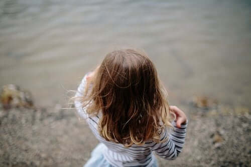 enfant au bord de l'eau avec cheveux détachés