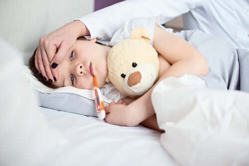 Un jeune garçon au lit, avec un thermomètre dans la bouche. 
