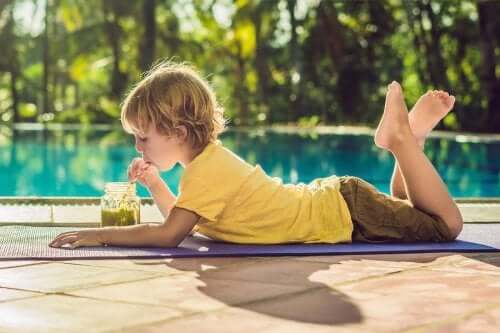 enfant buvant un smoothie près de la piscine