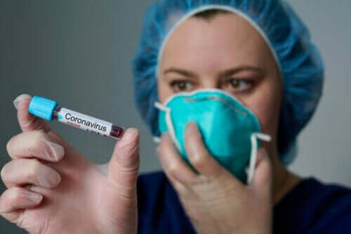 médecin tenant une fiole de sang infecté par le coronavirus