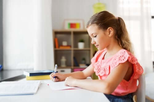 Une fille qui fait ses devoirs sur le bureau