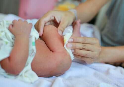 Maman changeant la couche de caca du nouveau né.