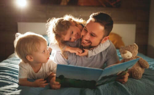papa qui lit un conte avec ses enfants dans le lit avant de dormir
