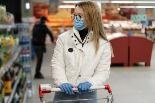 Une femme portant un masque et des gants en train de faire ses courses