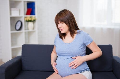 Une femme qui a des contractions et des douleurs pendant sa grossesse.