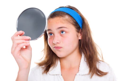 Une adolescente se regardant dans un miroir.