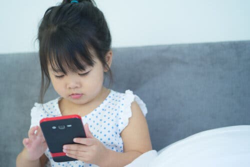 Une jeune fille qui utilise le téléphone portable du père.