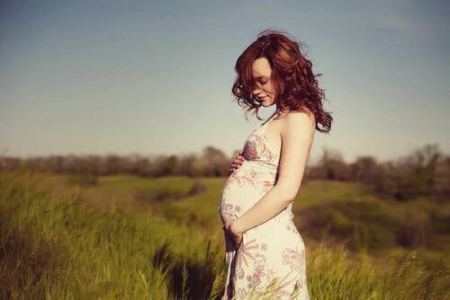 Une femme enceinte dans un champ.