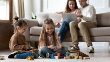 Des filles jouant ensemble devant leurs parents.