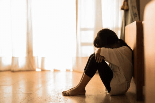 fille triste assise sur le sol