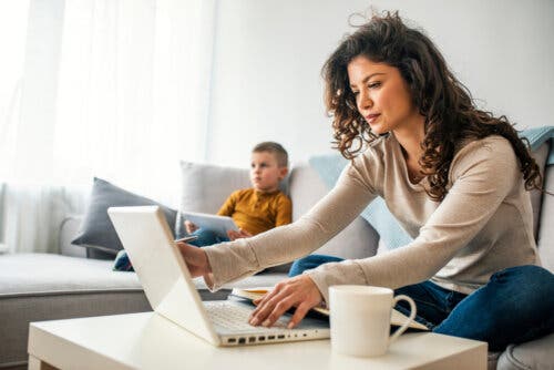 Une mère sur son ordinateur et son fils devant la télévision.