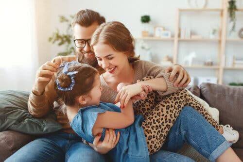 Des parents chatouillant leur fille.