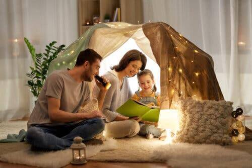 Des parents et une fille lisant sous une tente.