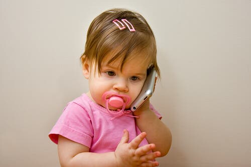 Une petite fille qui veut parler au téléphone